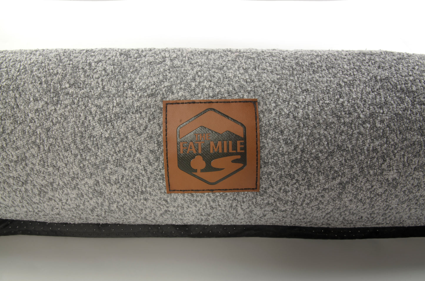 A gray chenille pet bed with a The Fat Mile square logo on the front.